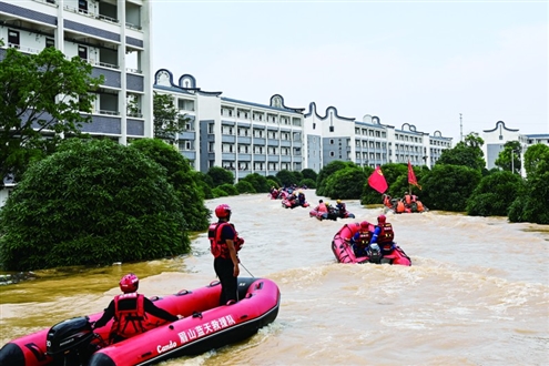 7月9日,在广西贵港市西江教育园区,大批救援人员乘坐橡皮艇去转运受困学生 新华社发